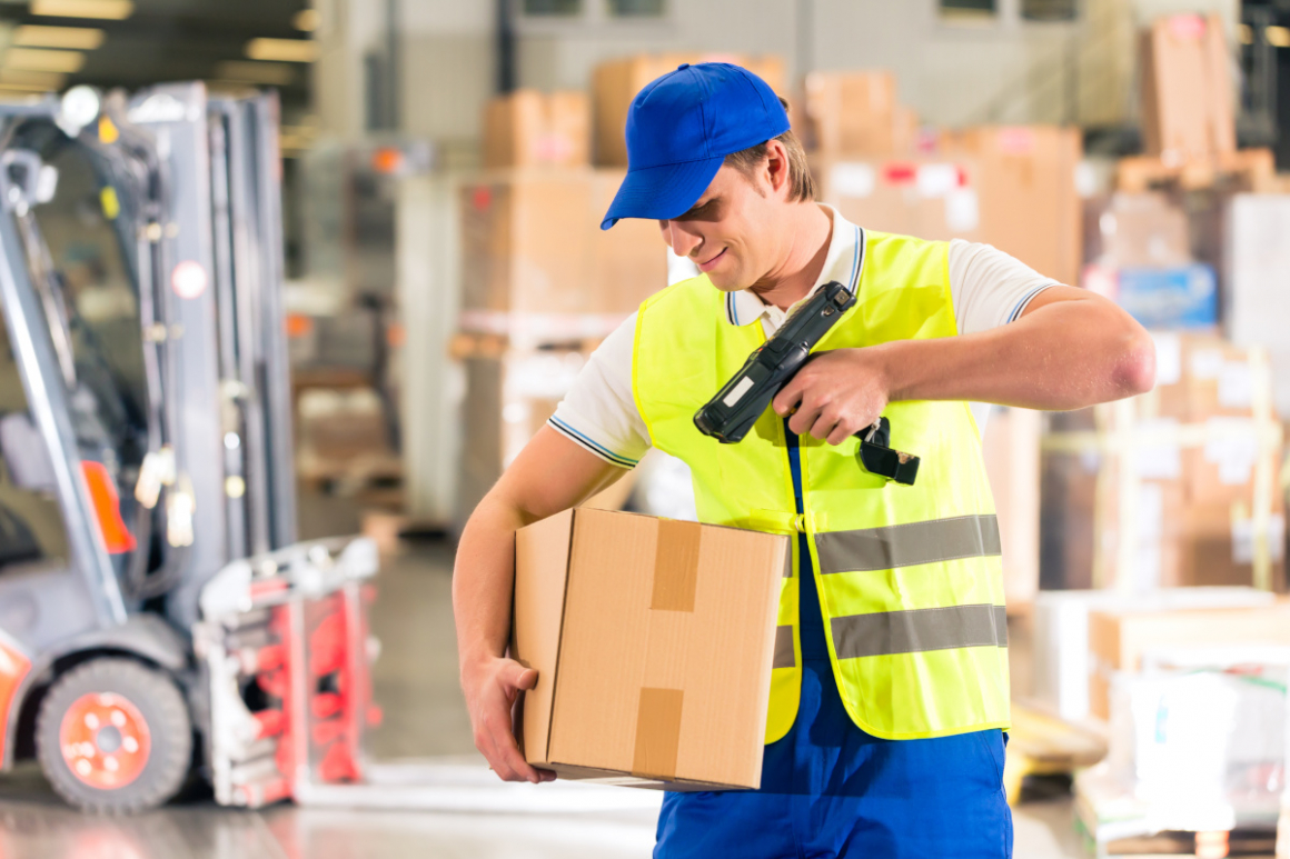 Logisitics - worker scans package in warehouse of forwarding