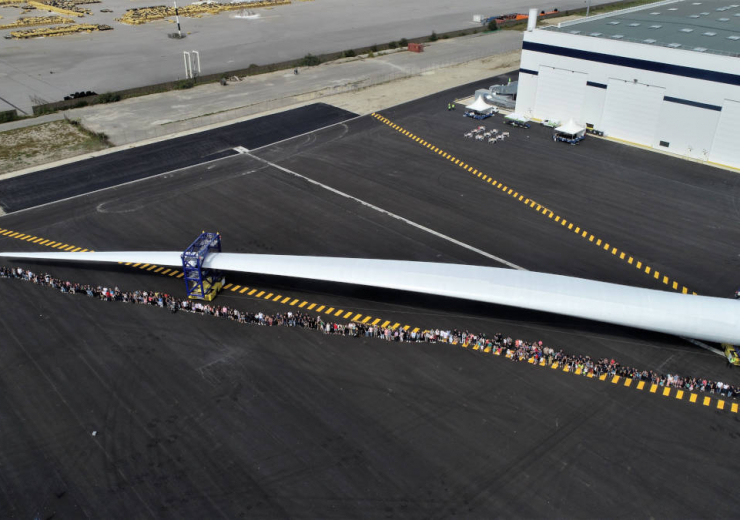 LM Wind Power employees next to a wind turbine blade