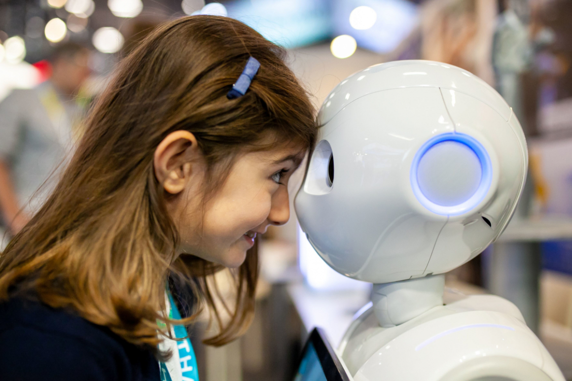 A little girl meets a robot in VivaTech